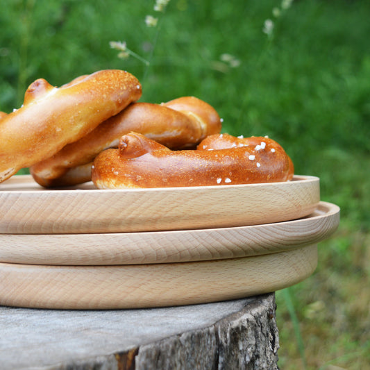 Pile d'assiettes en bois tournées à la main, fabriquées en France en Alsace, tournage sur bois artisanal. Pique-nique.