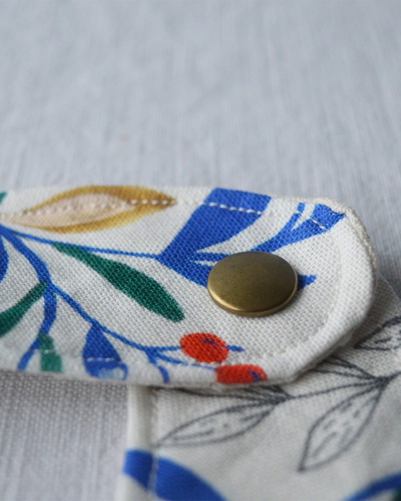 Bouton du bavoir en coton et lin à motif Primavera, tissé et fabriqué en France, sur fond blanc