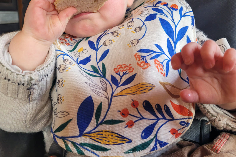 Bavoir en coton et lin à motif Primavera, tissé et fabriqué en France, porté par un bébé