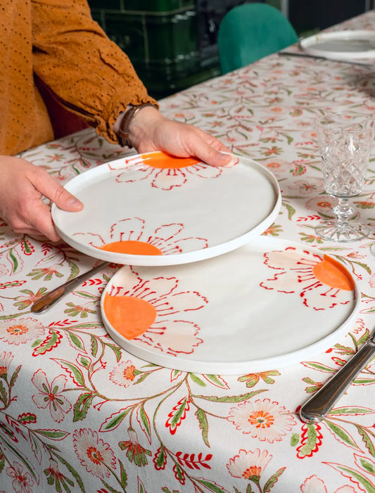 Grande assiette en porcelaine artisanale fabriquée en France, motif fleurs des champs colorées, sur nappe en coton et lin