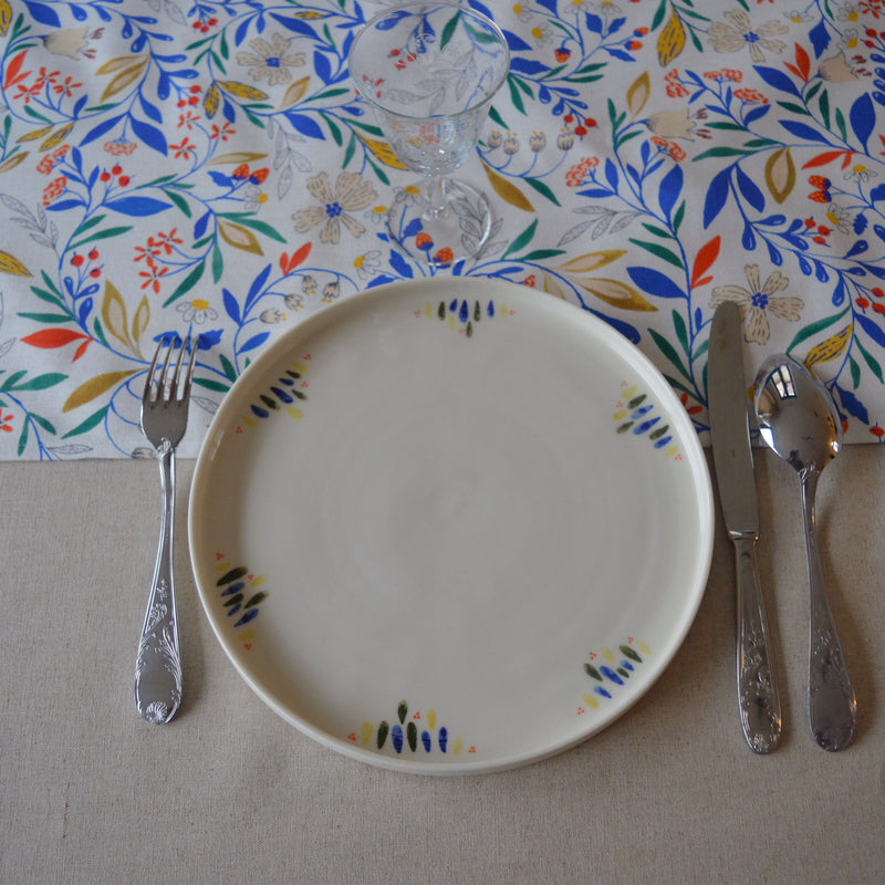 Porcelaine fabriquée en France, grande assiette à motif Primavera sur table dressée Maison Primavera