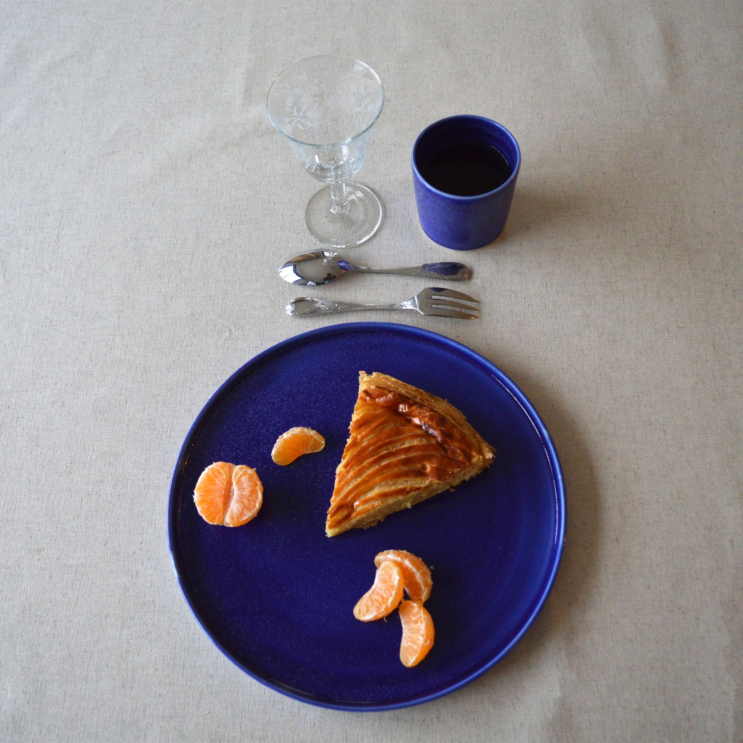 Porcelaine fabriquée en France, grande assiette bleue sur nappe naturelle en coton lin
