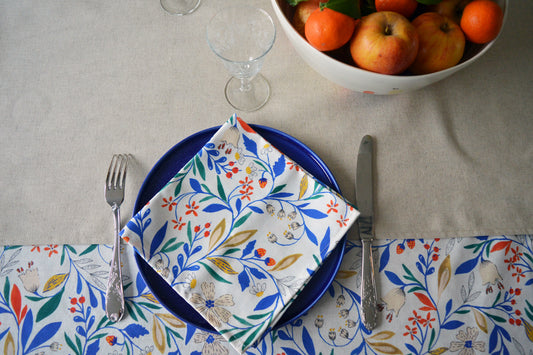 Porcelaine fabriquée en France, grande assiette bleue avec serviette à motif Primavera sur linge de table