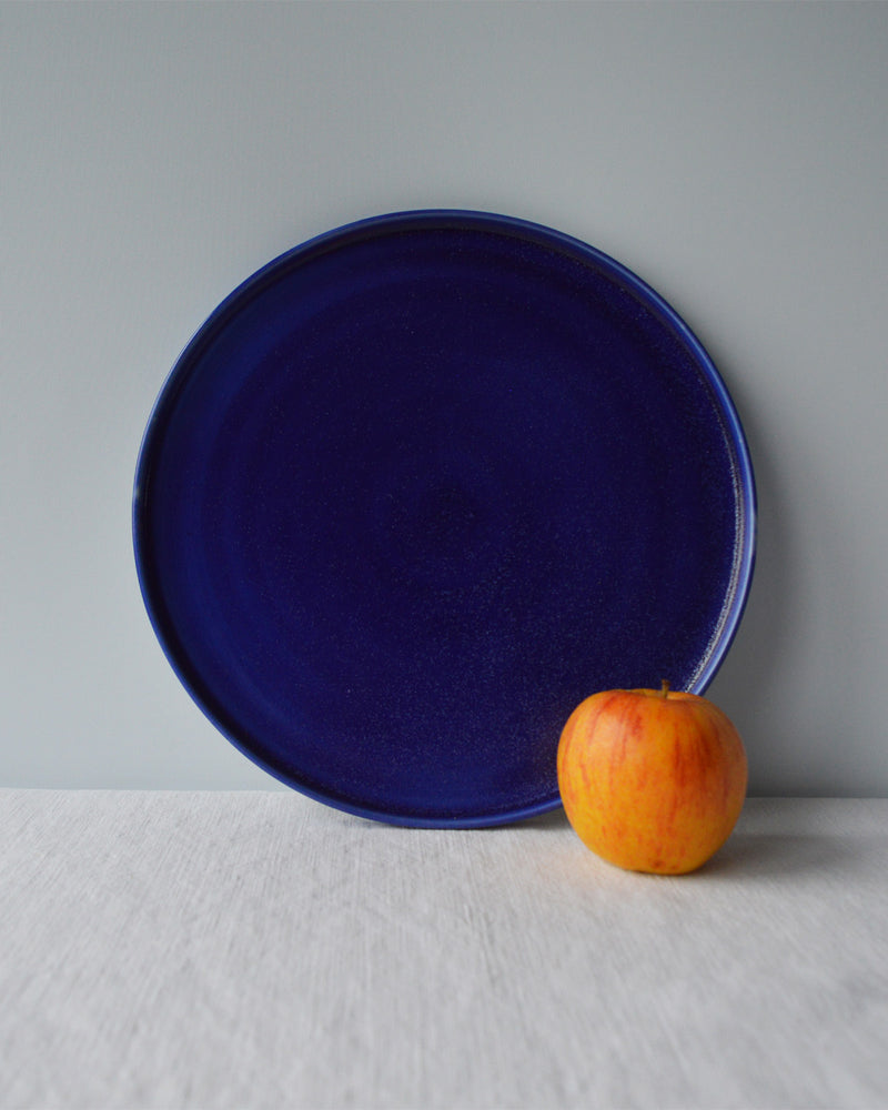 Porcelaine fabriquée en France, grande assiette bleue sur fond blanc