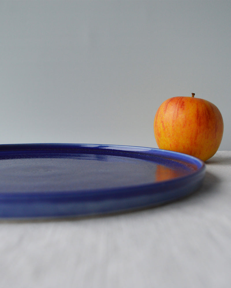 Porcelaine fabriquée en France, zoom sur grande assiette bleue sur fond blanc