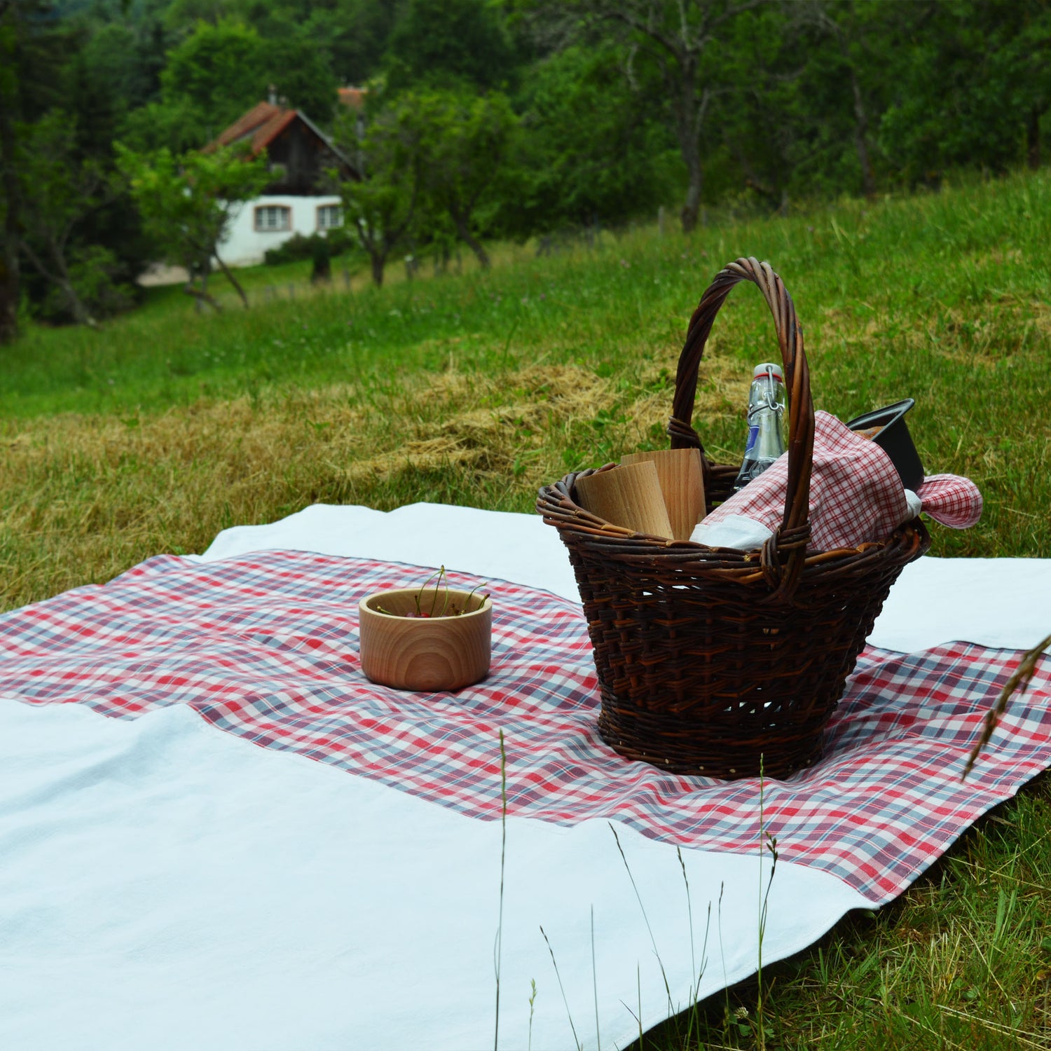 Nappe en kelsch rouge et bleu, et en lin, fabriquée en France en Alsace. Vaisselle en bois, panier en osier, artisanat, pique-nique