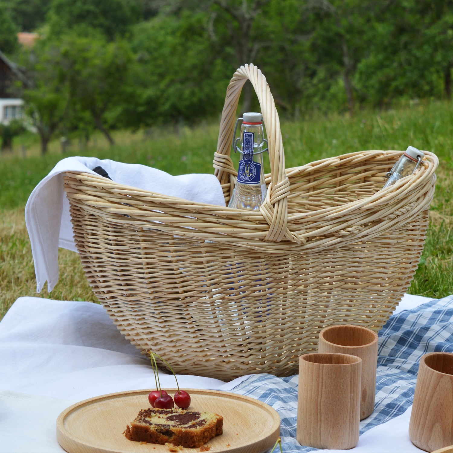 Panier en osier, grand et large, fabriqué artisanalement en France, vaisselle en bois artisanal et nappe en kelsch et lin