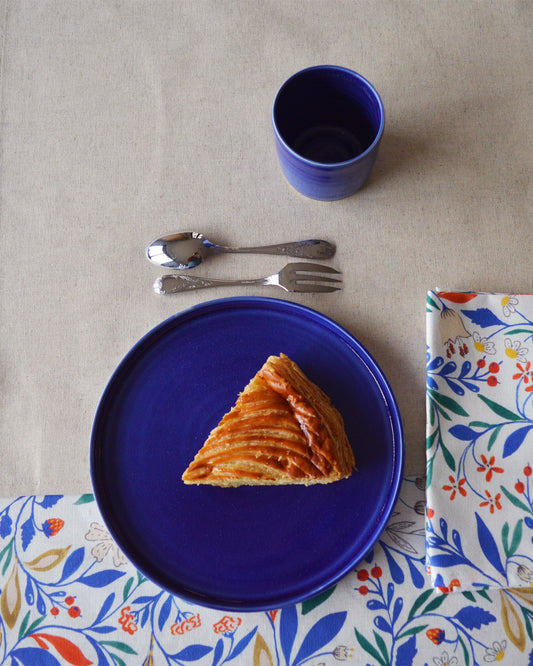 Porcelaine fabriquée en France, assiette à dessert bleue sur linge de table à motif et uni