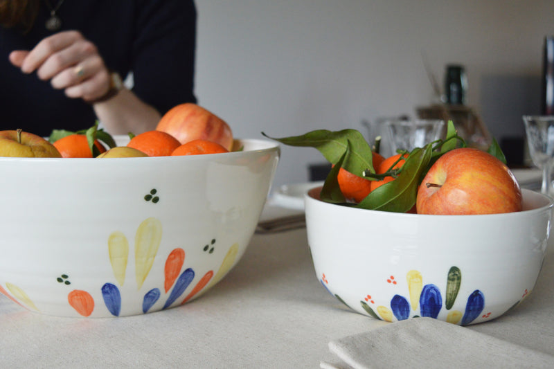 Porcelaine fabriquée en France, petit et grand saladiers à motif Primavera remplis de fruits sur table dressée
