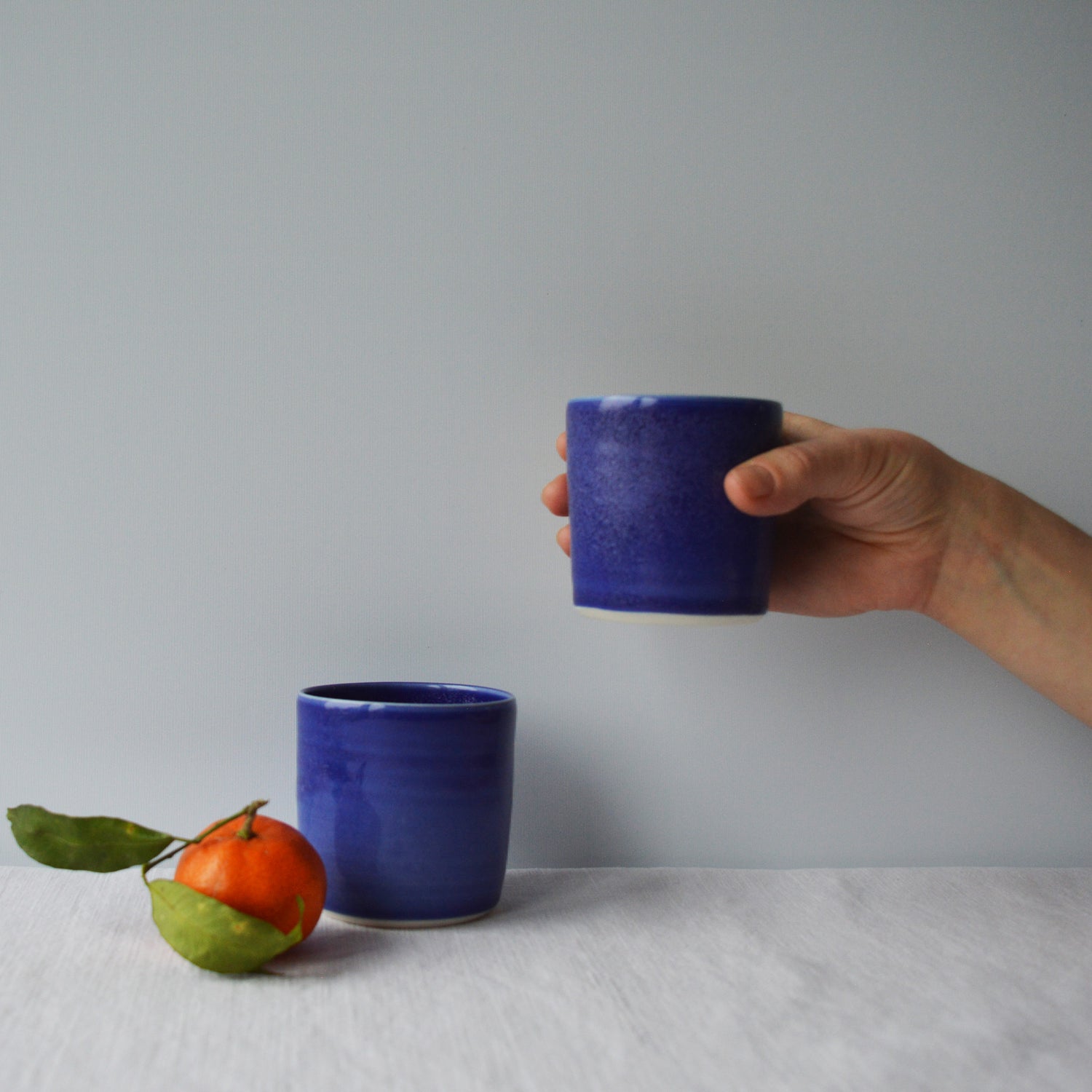 Porcelaine artisanale fabriquée en France, tasses à café bleues Maison Primavera sur fond blanc.