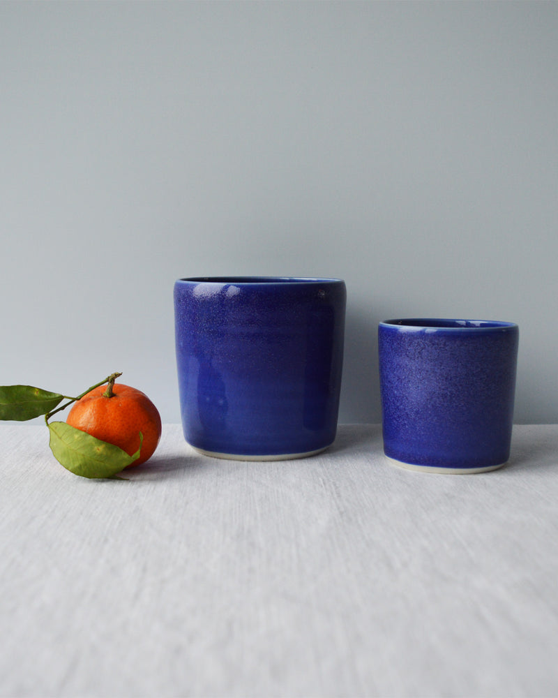 Porcelaine artisanale fabriquée en France, tasses à café et à thé bleues Maison Primavera sur fond blanc.
