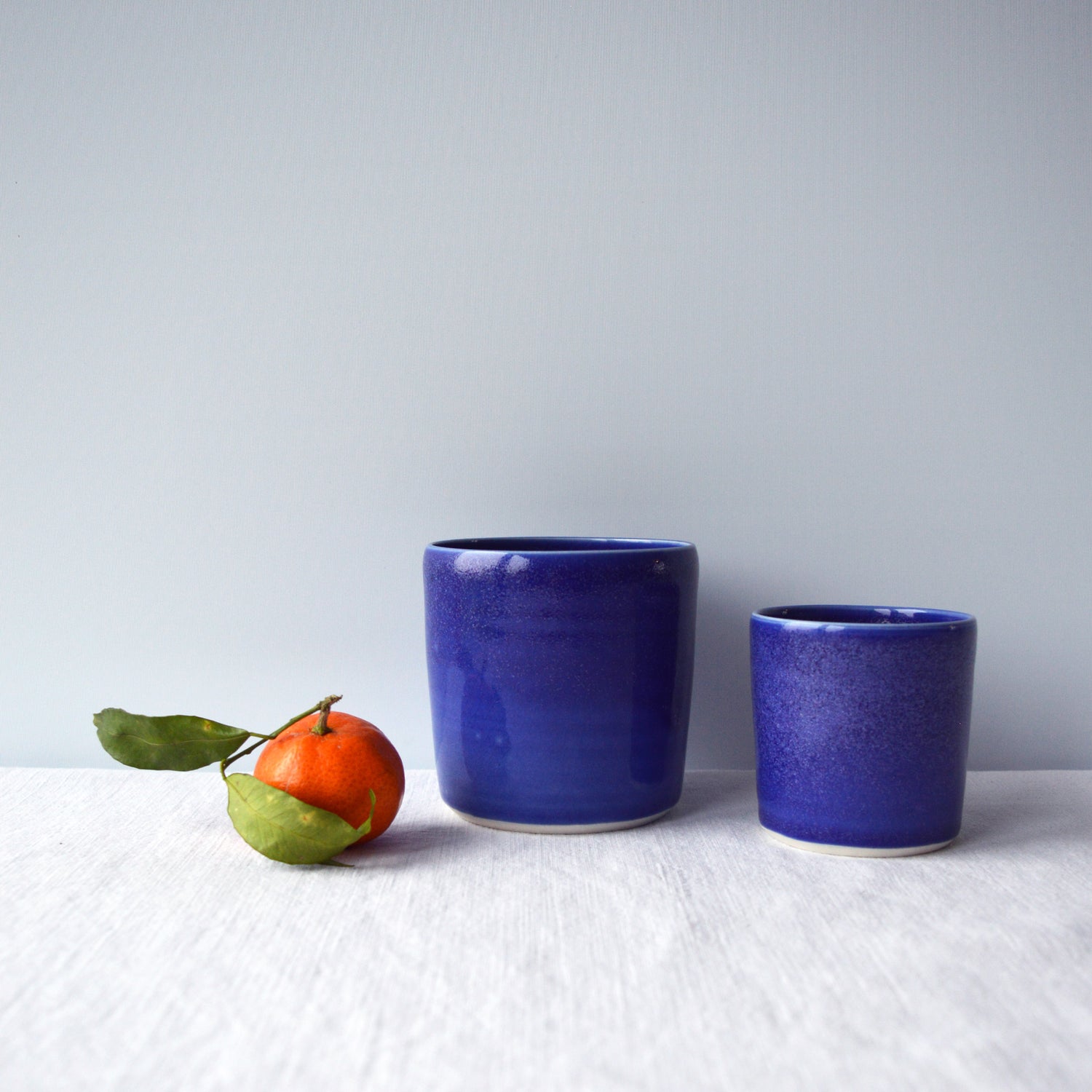 Porcelaine artisanale fabriquée en France, tasses à thé et à café bleues Maison Primavera sur fond blanc.