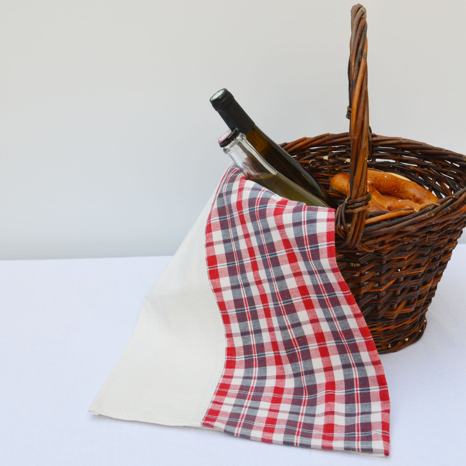 Torchon en kelsch rouge et bleu et en lin, fabriqué en France en Alsace. Panier en osier artisanal, bouteilles vin, pique-nique