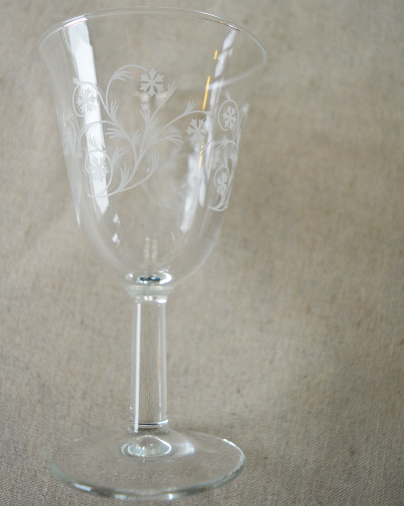 Verre à pied à motif floral chiné par Maison Primavera sur fond neutre