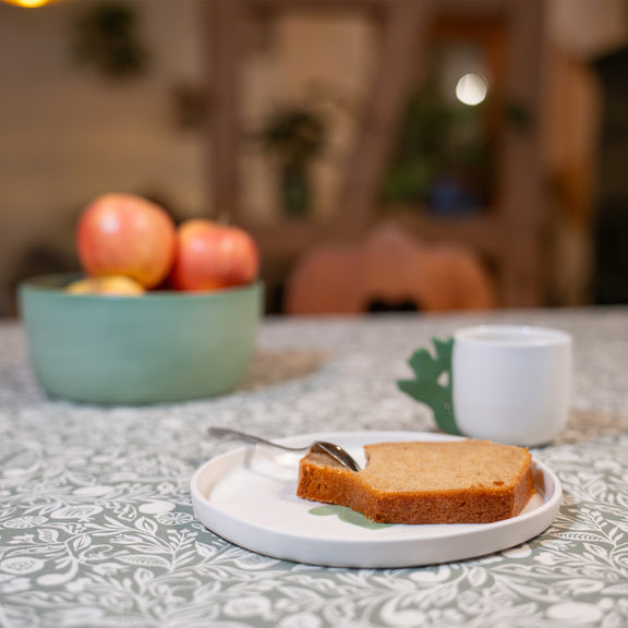 Assiette à dessert artisanale en porcelaine, fabriquée en France, blanche avec un motif cœur alsacien vert, mise en scène sur une table déco made in France