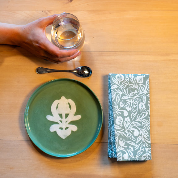 Assiette à dessert verte à motif blanc, en porcelaine, fabriquée en France artisanalement, motif arbre de vie alsacien, serviette à motif made in France motif floral