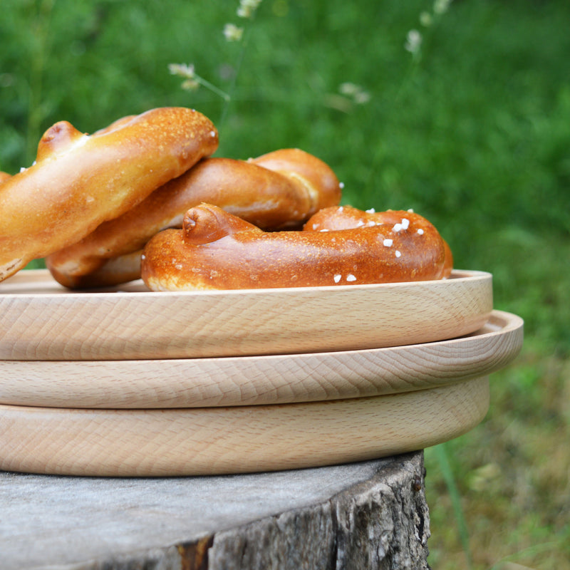 Pile d'assiettes en bois tournées à la main, fabriquées en France en Alsace, tournage sur bois artisanal. Pique-nique.
