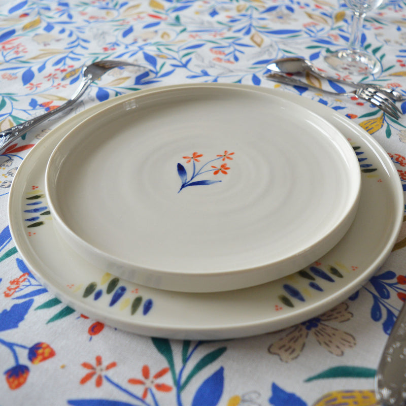 Porcelaine fabriquée en France, assiette à dessert à motif Ostara sur grande assiette à motif Primavera, table dressée 