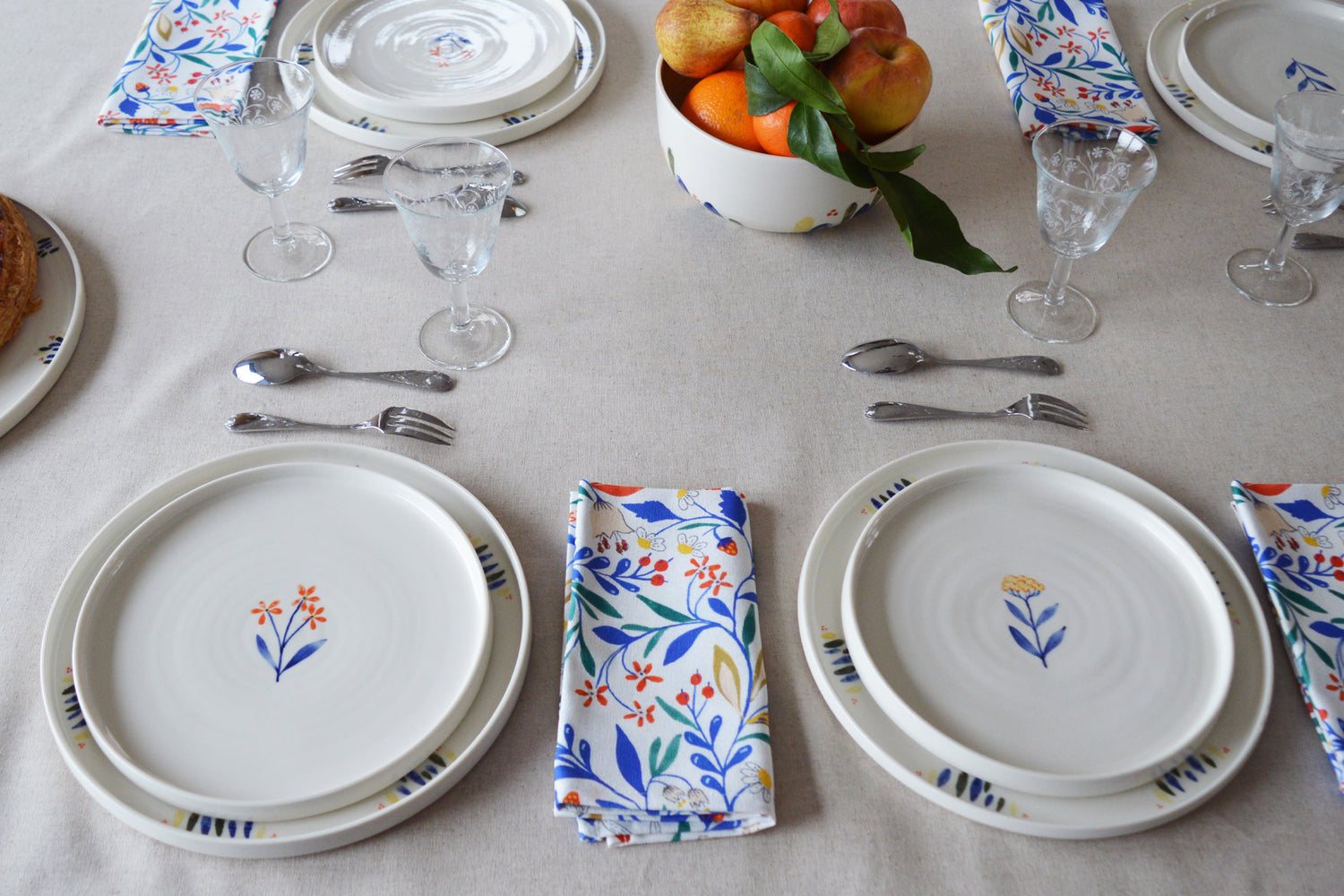 Porcelaine fabriquée en France, assiettes à dessert à motif Ostara et Flora sur grandes assiettes à motif Primavera, table dressée 
