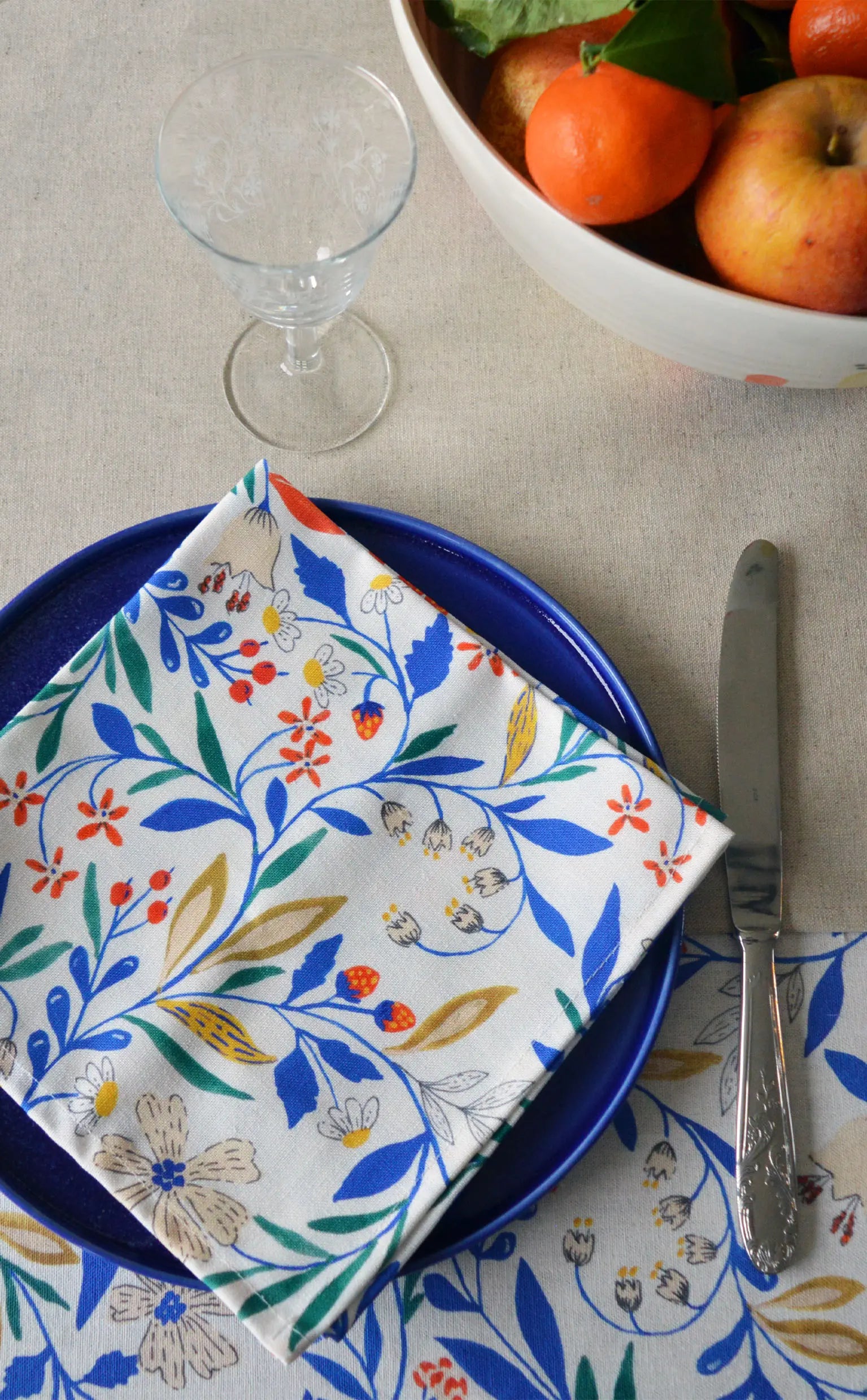 Serviette à motif floral sur table dressée avec linge de table français et céramique artisanale