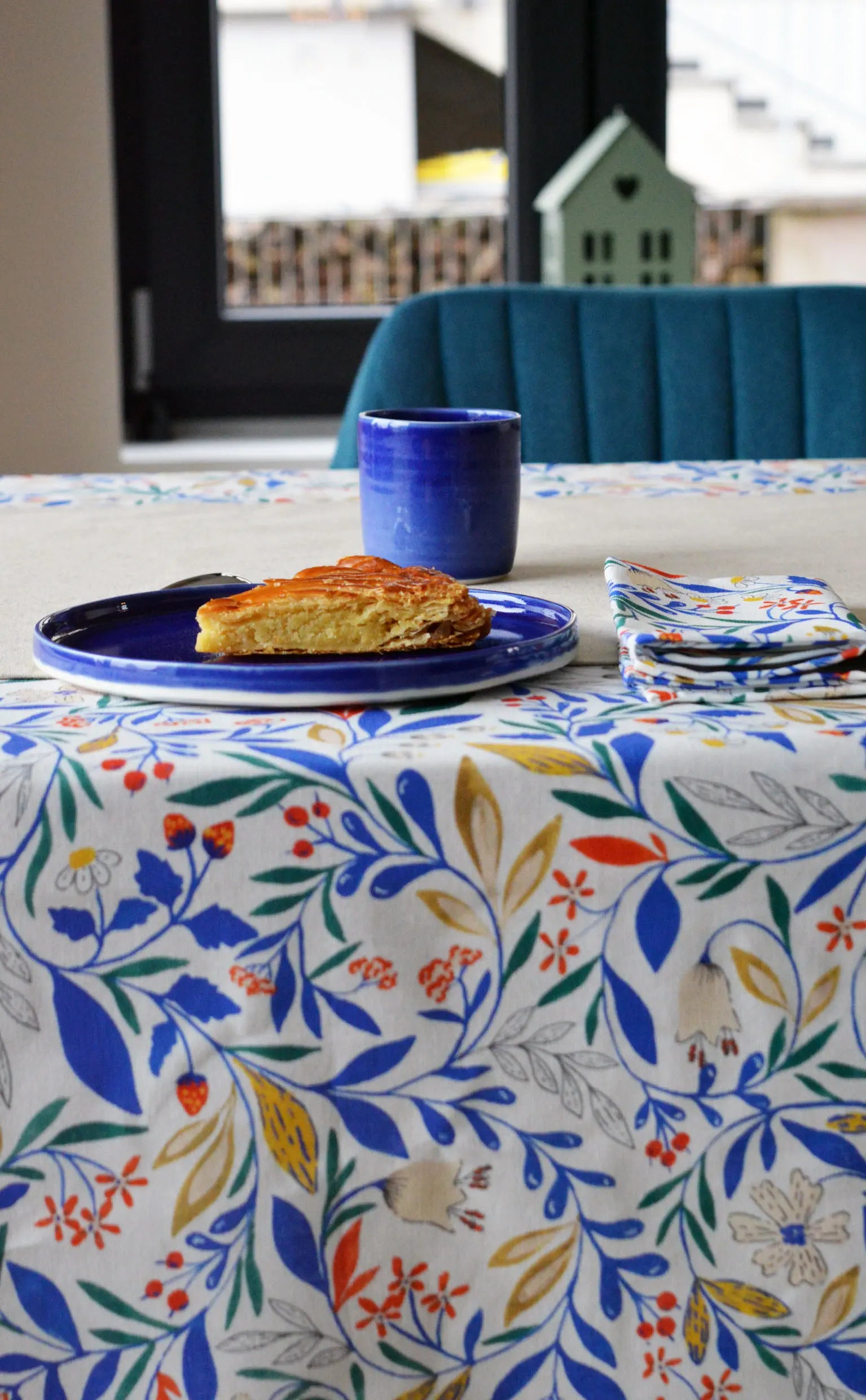 Table dressée Primavera avec nappe à motif fleuri et coloré, céramique en porcelaine artisanale bleue