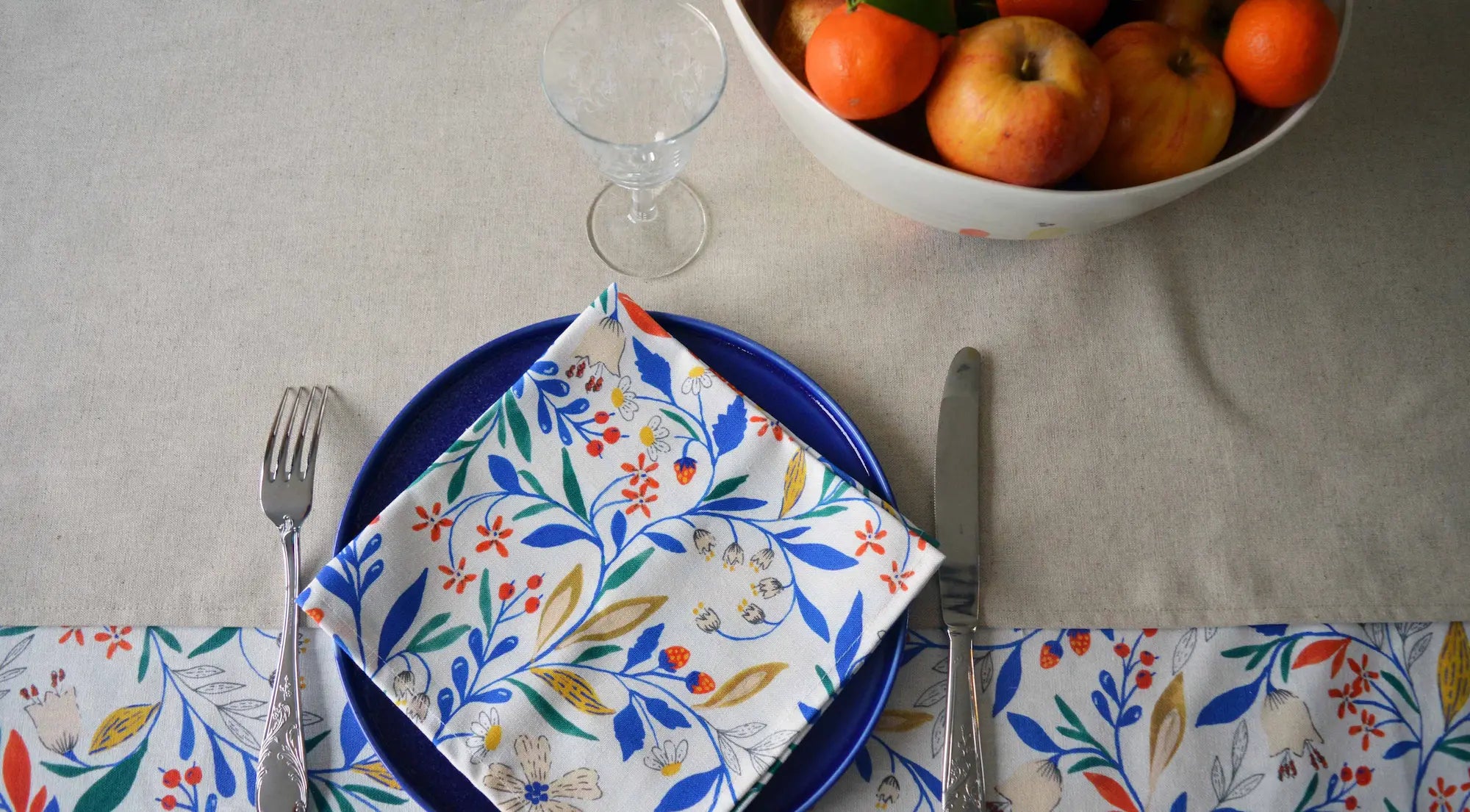 Serviette à motif floral sur table dressée avec linge de table français et céramique artisanale
