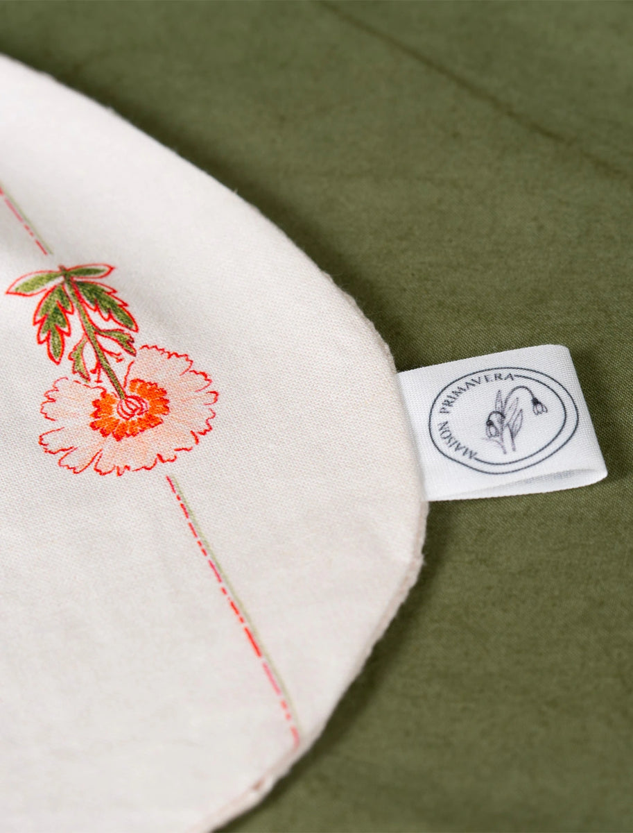 Détail d'un bavoir fabriqué en France avec motif floral sur coton et lin