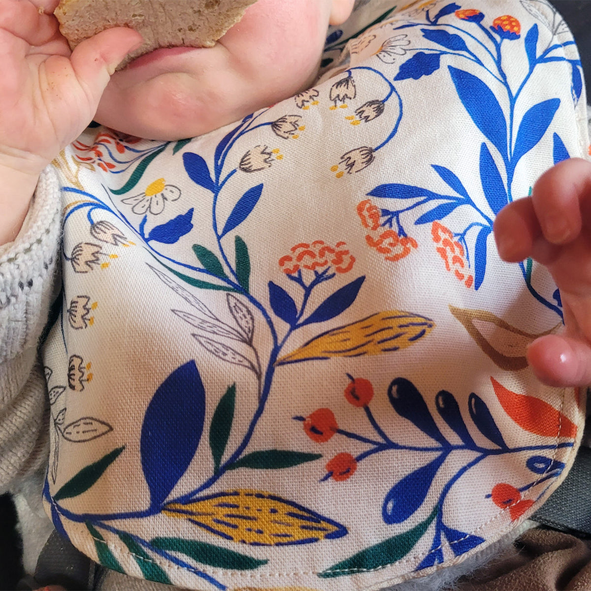 Bavoir en coton et lin à motif Primavera, tissé et fabriqué en France, porté par un bébé