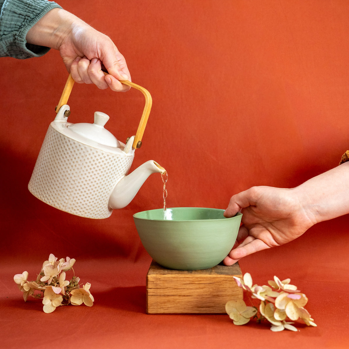 Bol vert en porcelaine, fabriqué en France, artisanal, qu'on remplit avec une théière blanche