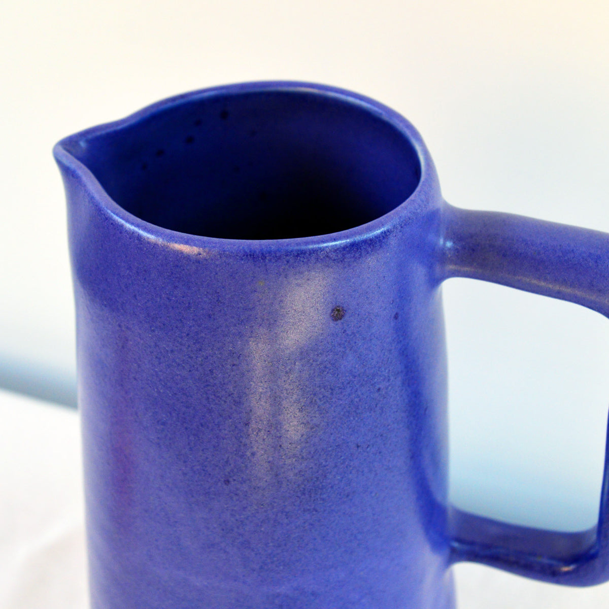 Porcelaine fabriquée en France, haut d'une carafe bleu Primavera sur fond blanc