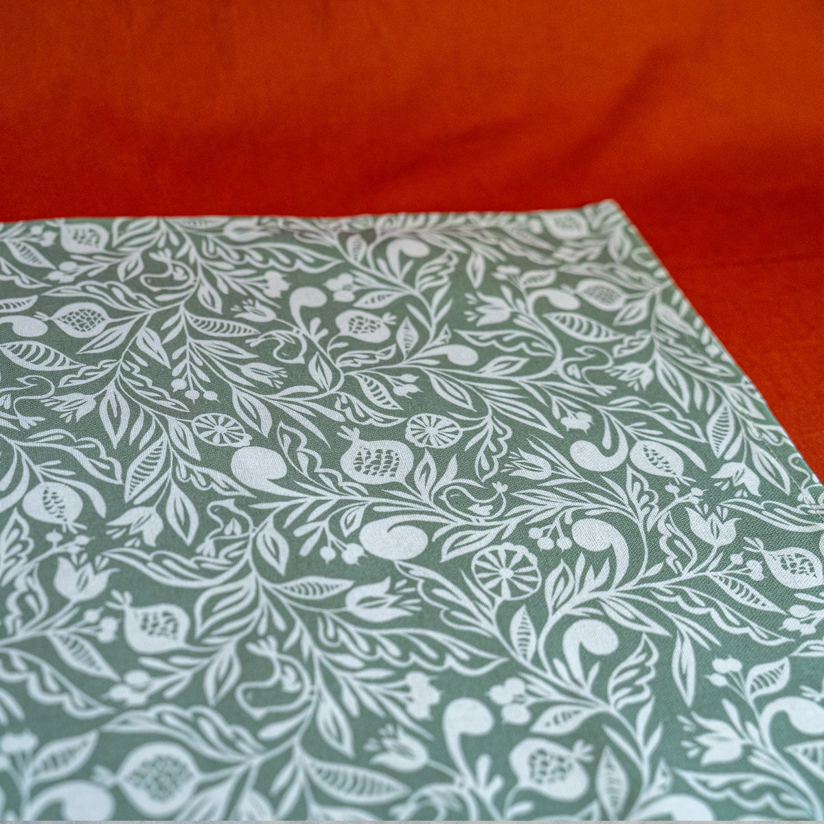 Zoom sur chemin de table fabriqué en France, vert et blanc, en coton et lin, motif floral polychrome alsacien