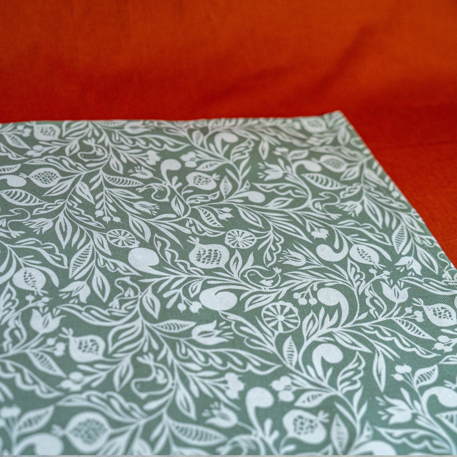 Zoom sur chemin de table fabriqué en France, vert et blanc, en coton et lin, motif floral polychrome alsacien