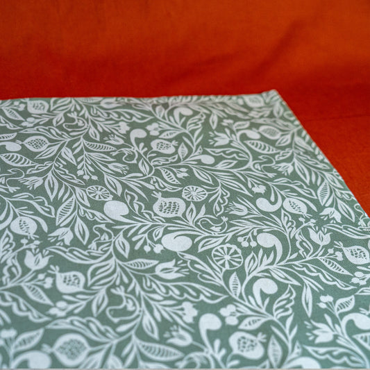 Zoom sur chemin de table fabriqué en France, vert et blanc, en coton et lin, motif floral polychrome alsacien