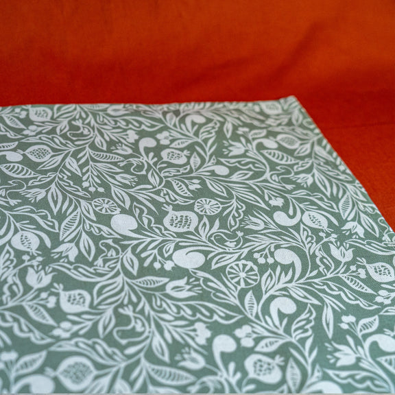 Zoom sur chemin de table fabriqué en France, vert et blanc, en coton et lin, motif floral polychrome alsacien