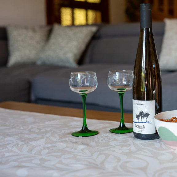 Chemin de table fabriqué en France, beige et blanc, en coton et lin, motif floral arbre de vie Alsace, bouteille vin d'Alsace, verres, bol artisanal en porcelaine