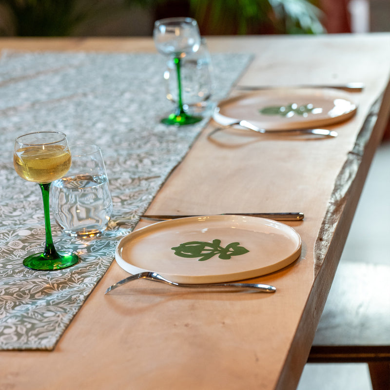 Grande assiette en porcelaine fabriquée en France, artisanale, blanche à motif vert cœur alsacien, table mise avec chemin de table et verres