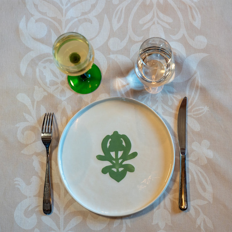 Grande assiette en porcelaine fabriquée en France, artisanale, blanche à motif vert cœur alsacien, avec verre de vin d'Alsace et couverts, nappe made in France