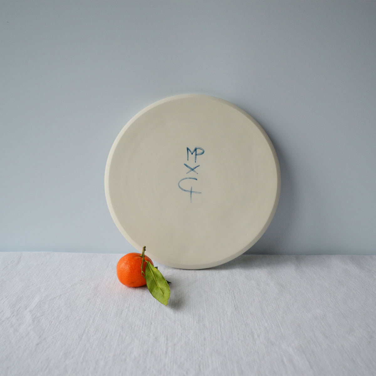Porcelaine fabriquée en France, dos de la grande assiette Primavera sur fond blanc