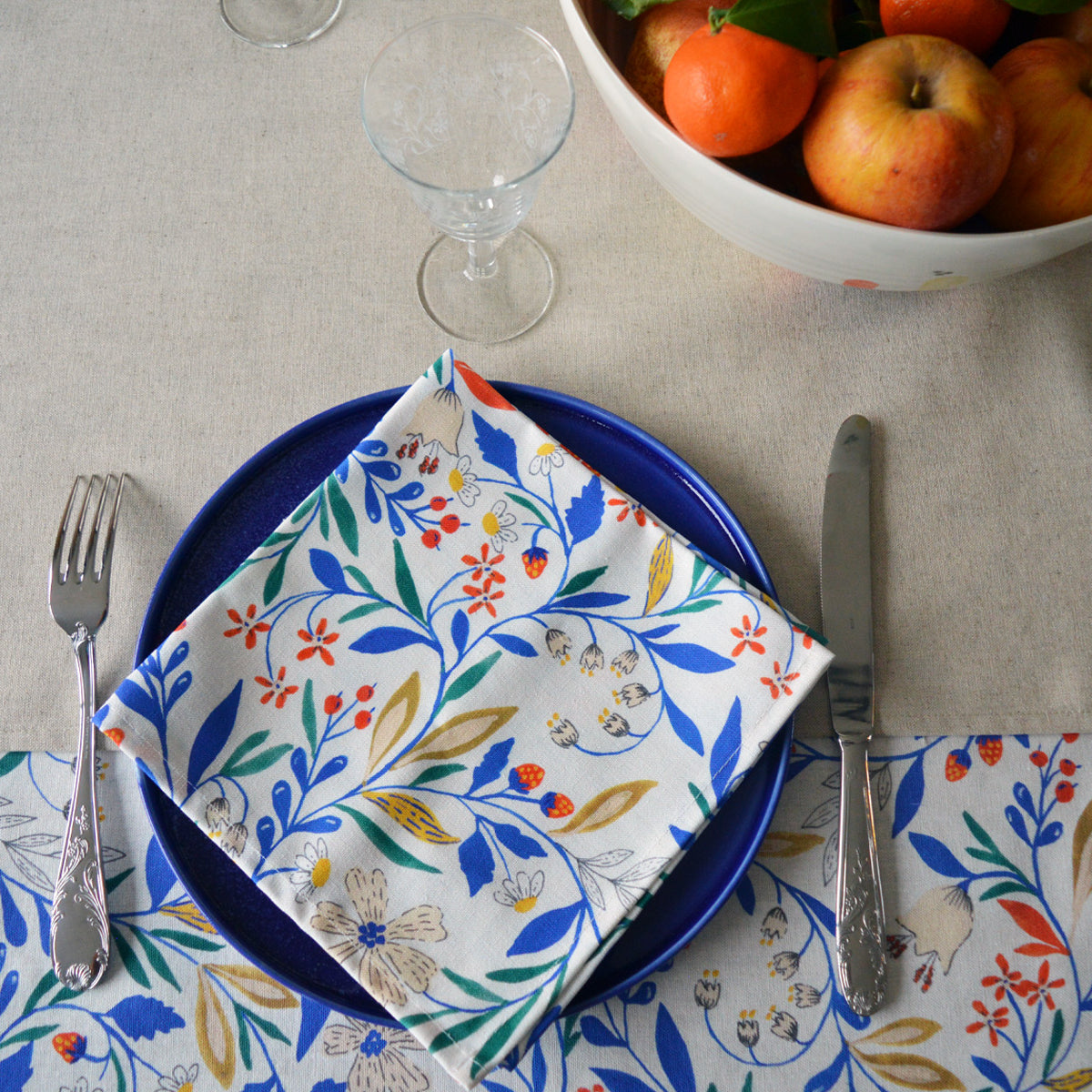 Porcelaine fabriquée en France, grande assiette bleue avec serviette à motif Primavera sur linge de table