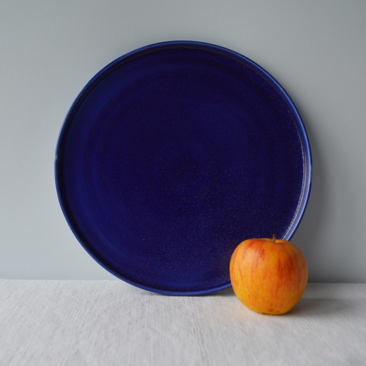 Porcelaine fabriquée en France, grande assiette bleue sur fond blanc