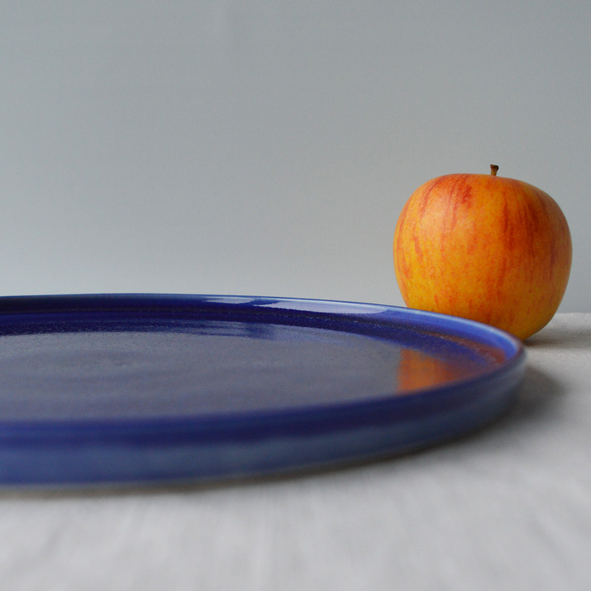 Porcelaine fabriquée en France, zoom sur grande assiette bleue sur fond blanc