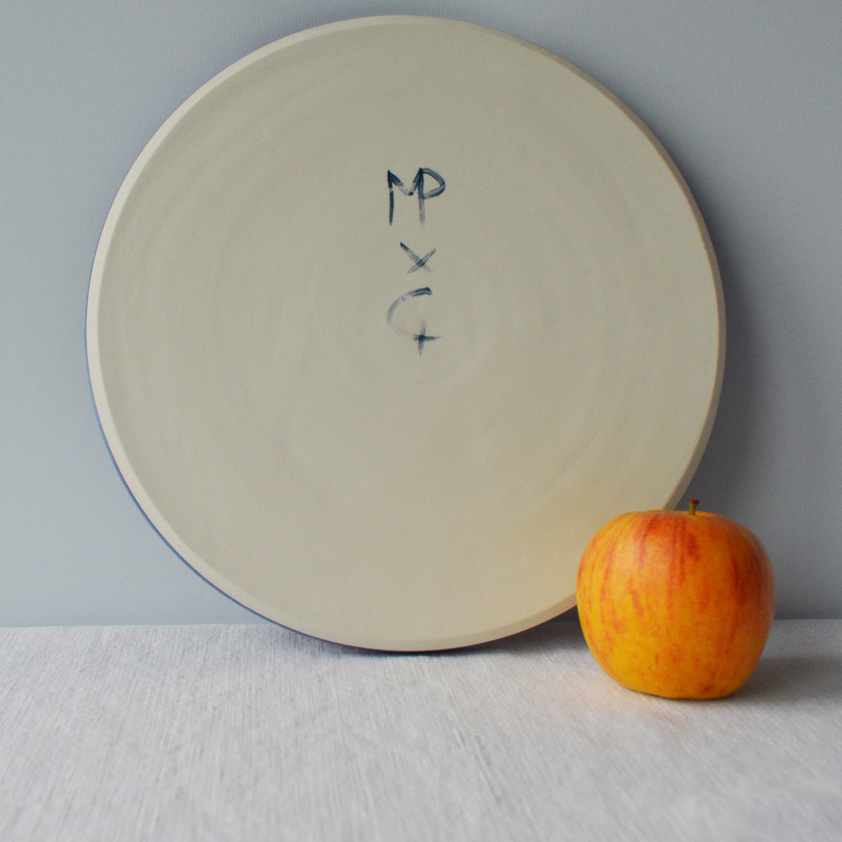 Porcelaine fabriquée en France, dos de grande assiette bleue sur fond blanc