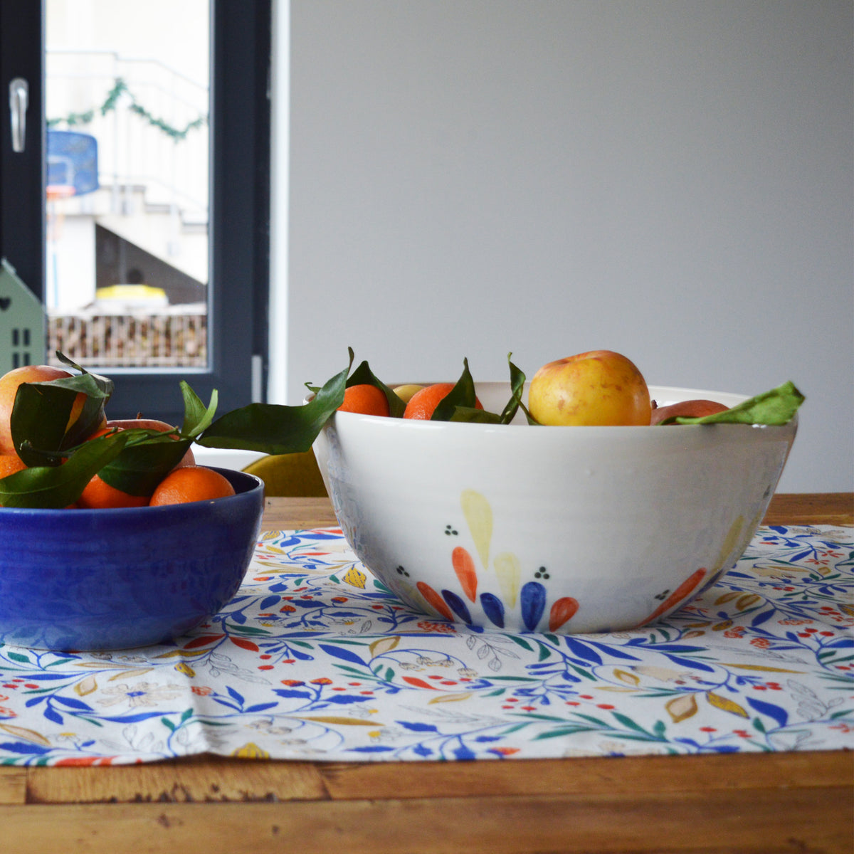 Porcelaine fabriquée en France, grand saladier à motif Primavera rempli de fruits sur table