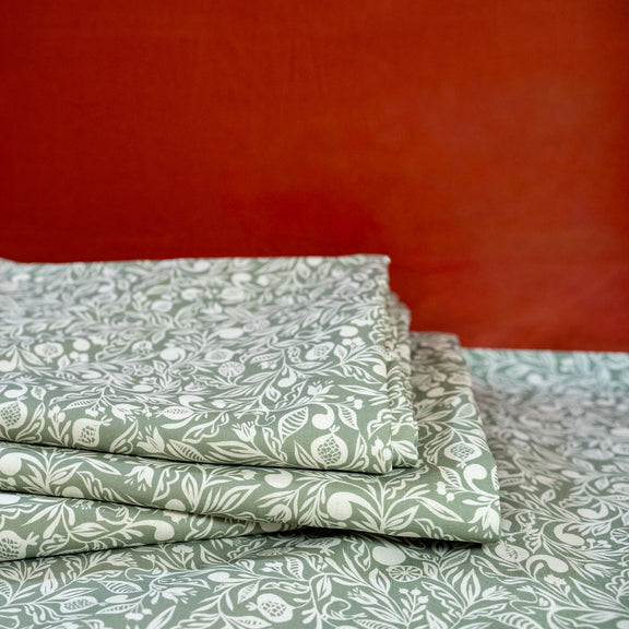 Pile de nappes vertes et blanches, fabriquées en France, en coton et lin certifié Oeko Tex, motif floral polychrome Alsace