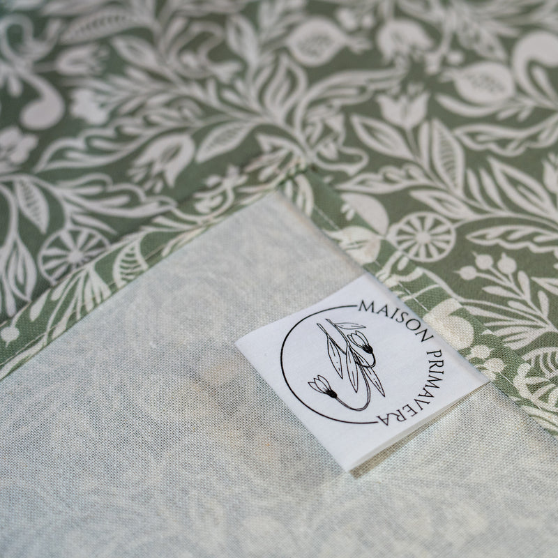 Détail étiquette nappe verte et blanche, fabriquée en France, en coton et lin certifié Oeko Tex, motif floral polychrome Alsace