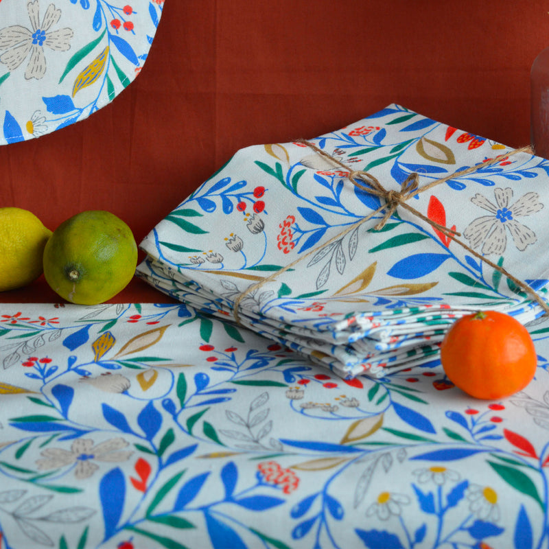 Zoom sur lot de bavoir, serviettes et chemin de table fabriqués en France dans les Vosges, motif floral et coloré