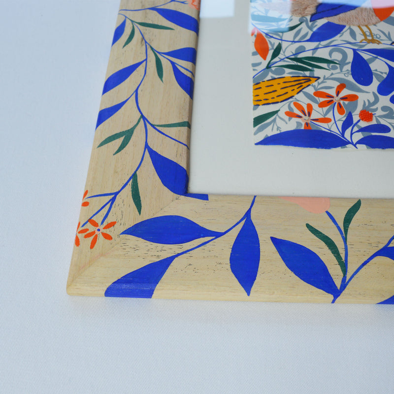 Peinture brodée à la main, aux motifs fleuris et aux couleurs vives. Cadre en bois peint à la main, motif floral.