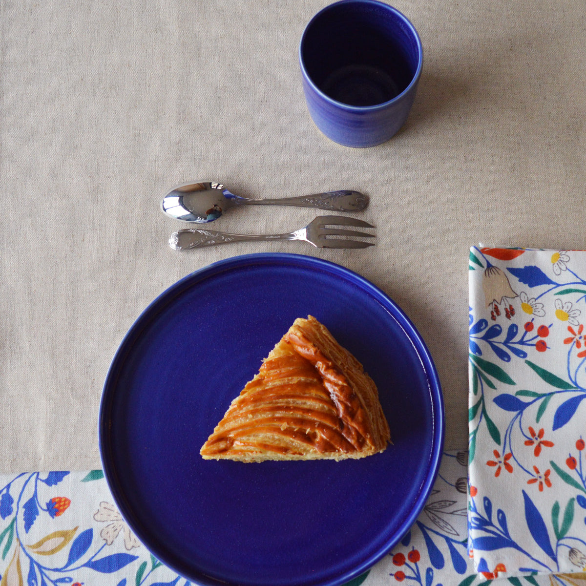 Porcelaine fabriquée en France, assiette à dessert bleue sur linge de table à motif et uni