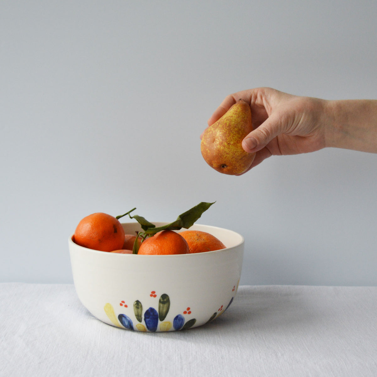 Porcelaine fabriquée en France, petit saladier à motif Primavera rempli de fruits sur fond blanc
