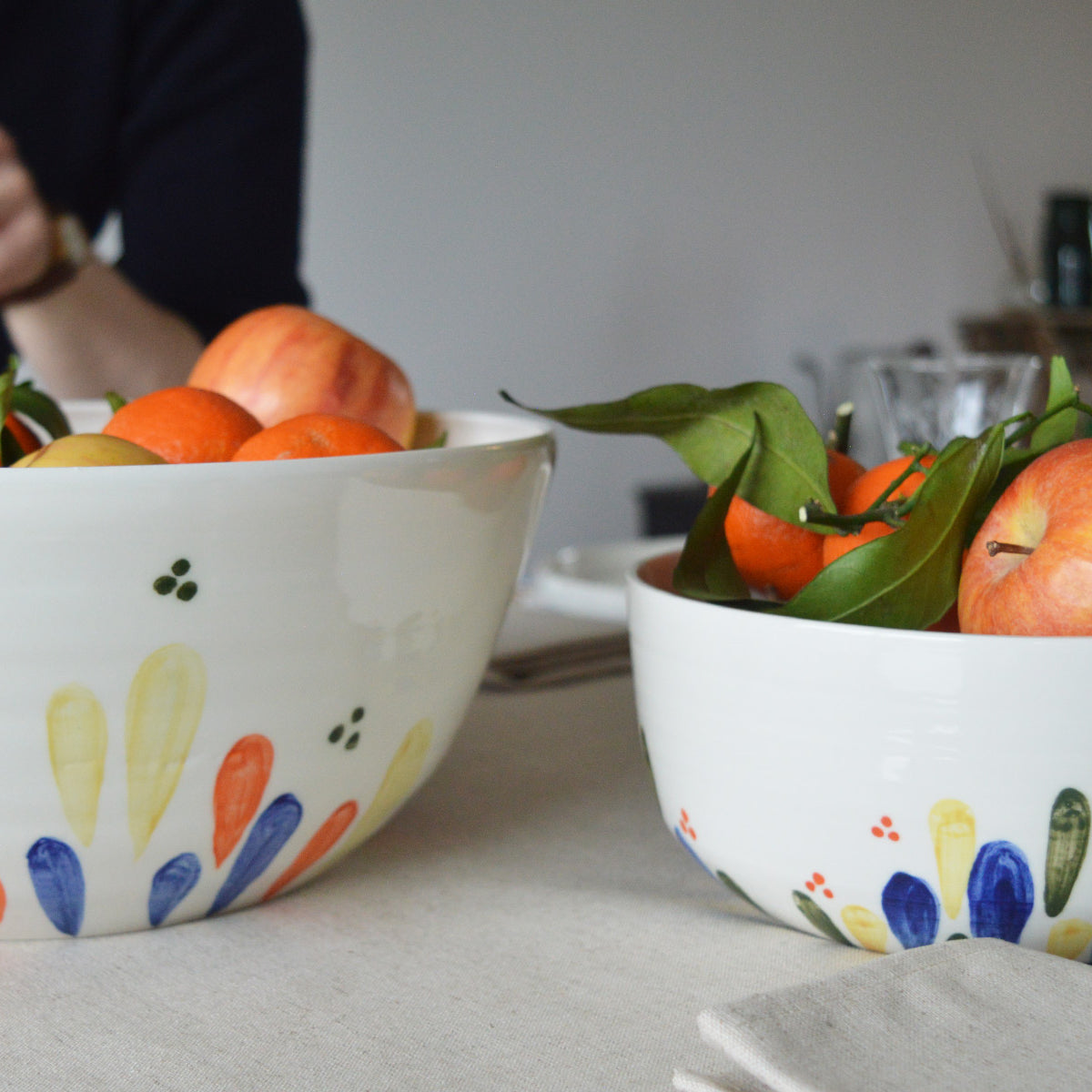 Porcelaine fabriquée en France, petit et grand saladiers à motif Primavera remplis de fruits sur table dressée